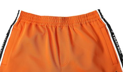 Orange sweatpants with black trim men side sportswear retro for
